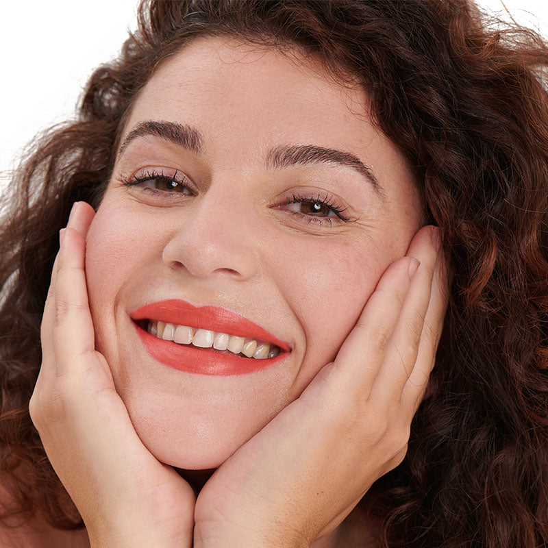 Teinte corail du rouge à lèvres naturel et clean Pomponne sur peau mate